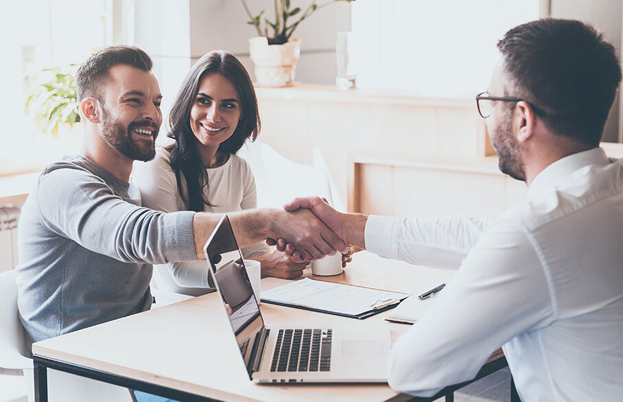 Couple shake hands with a landlord