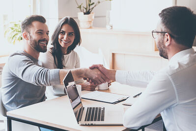 Couple shake hands with a landlord