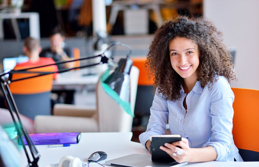 Person looking at the camera whilst sat at a desk