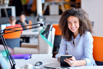 Person looking at the camera whilst sat at a desk