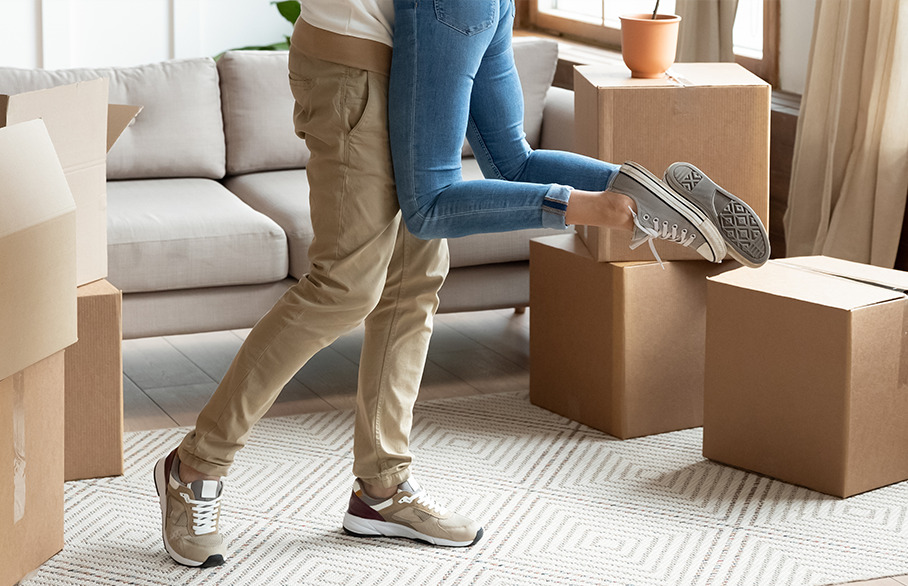 Couple embracing with moving boxes
