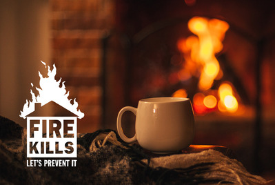 Mug in front of fire with Fire Kills logo