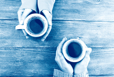 Two pairs of hands holding warm mugs, blue wash