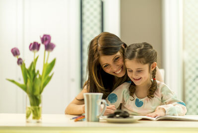 Family reading a book at the table