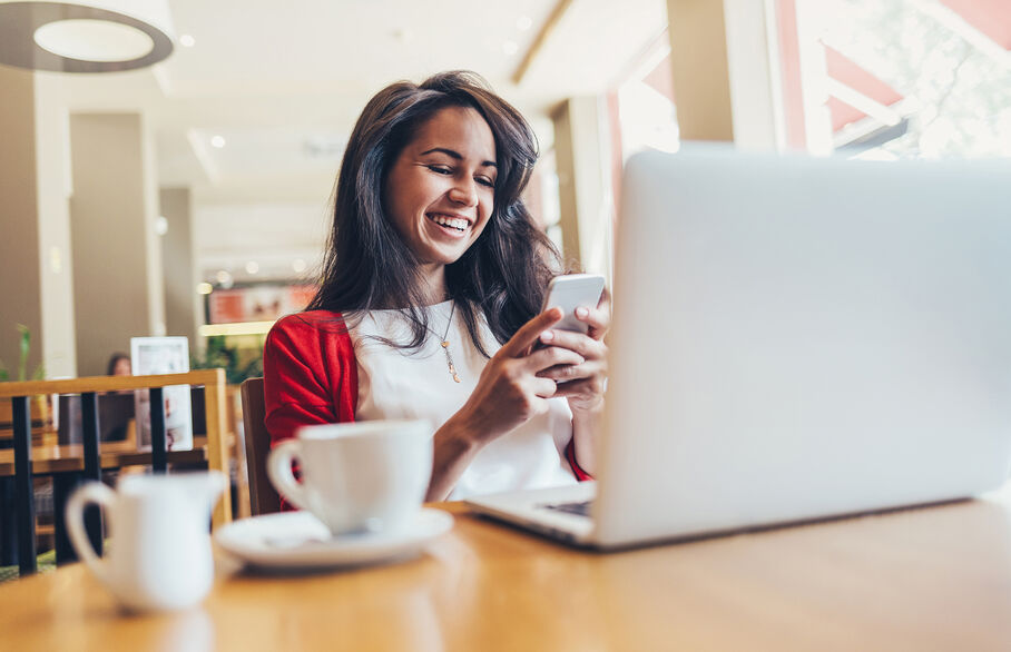 Woman smiling happily at her phone