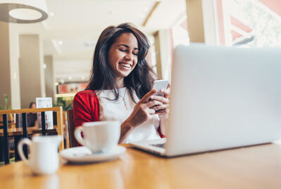 Woman smiling happily at her phone