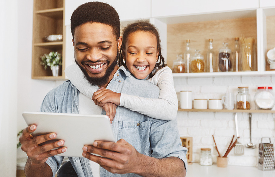 Man and child looking at a device smiling