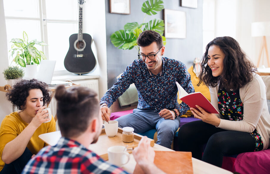 People sat round a low table chatting and smiling