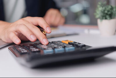 Close up of hand and calculator 