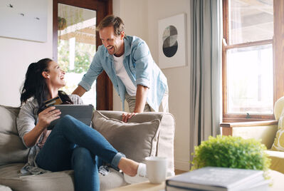 A couple smiling at each other in the living room