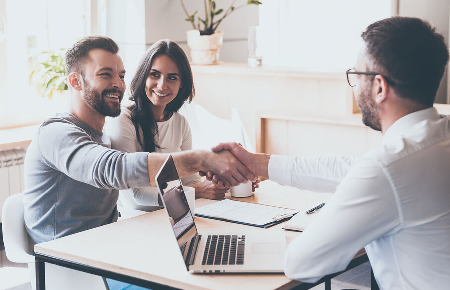 couple shaking hands with man