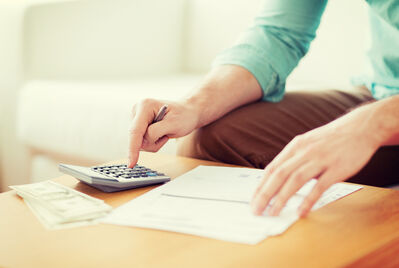 Person using a calculator and writing notes