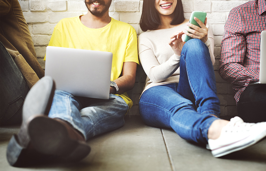 Smiling people sat against a wall