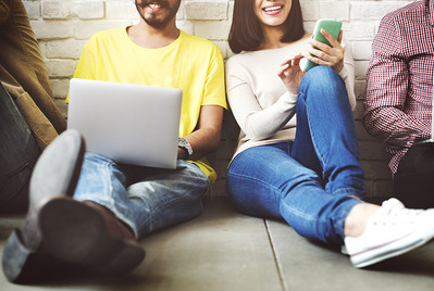 Smiling people sat against a wall