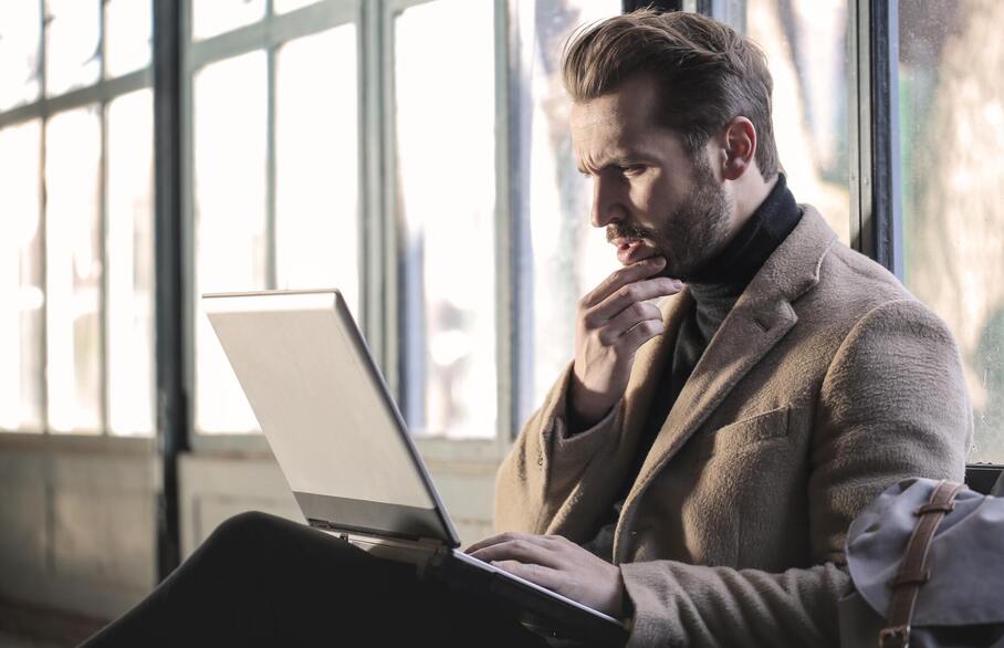 Confused man looking at laptop