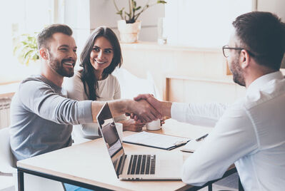 Couple shaking hands with an adviser