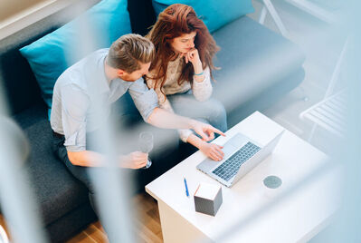 Couple sat in front of their laptop