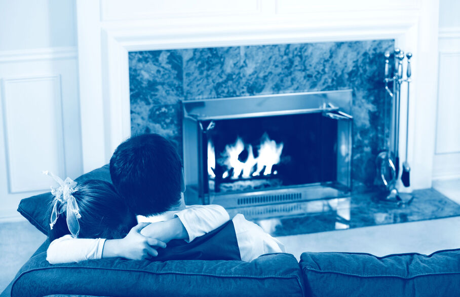 Couple on the sofa in front of a fireplace