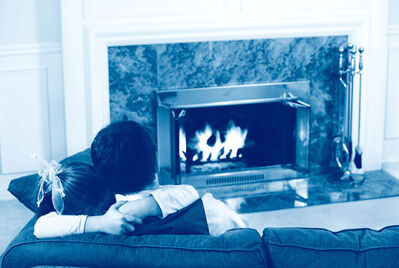 Couple on the sofa in front of a fireplace