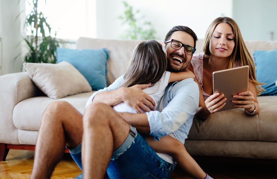 Family sat on the sofa looking at an ipad