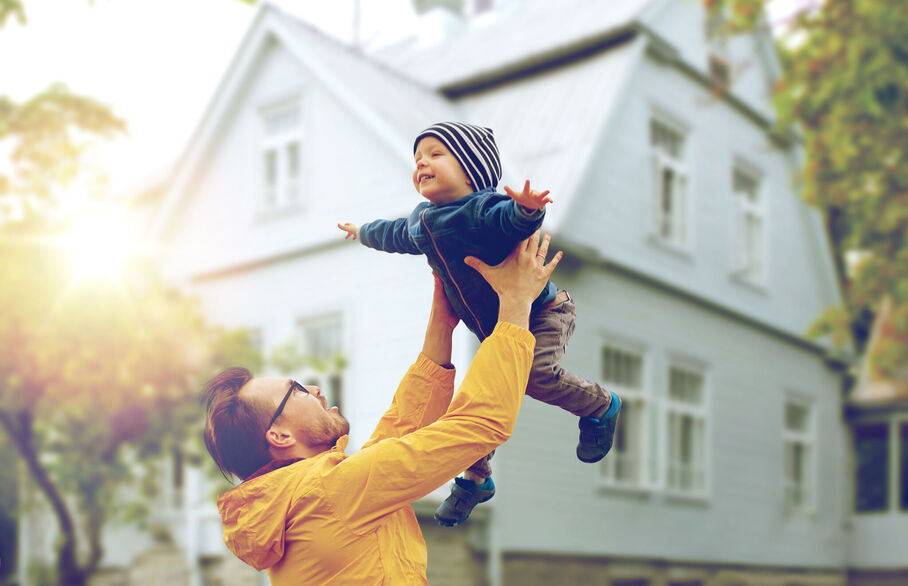 Man playfully throwing his son up in the air