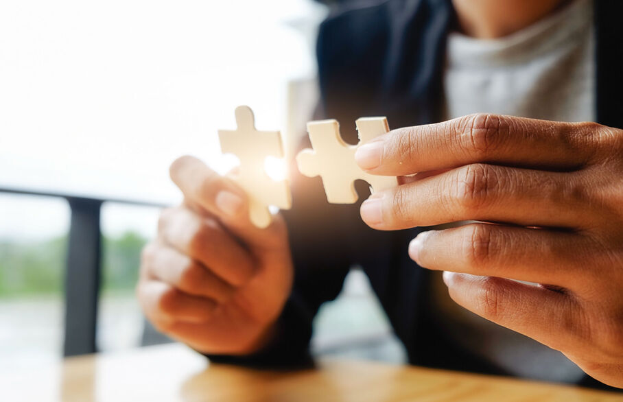 Person holding two pieces of jigsaw