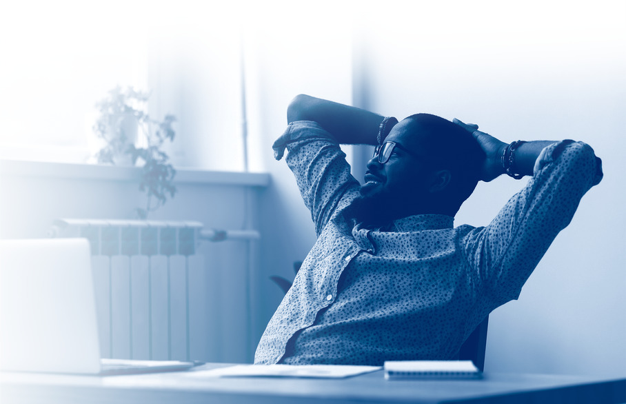 Person sitting in a chair with their hands behind their head