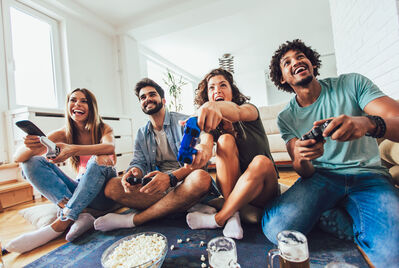 People gaming and sat looking at a TV